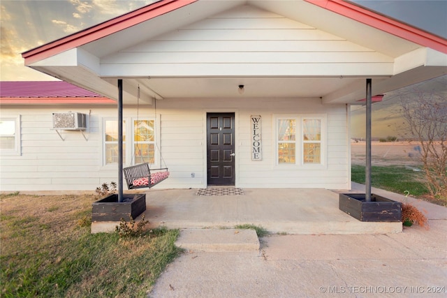 view of front of property with a wall mounted air conditioner and a porch