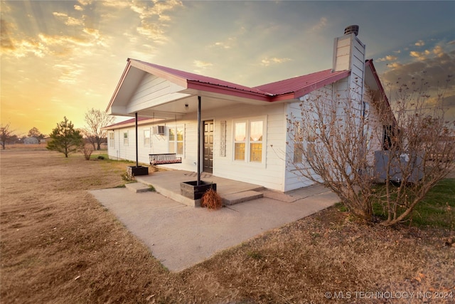 back house at dusk with a porch