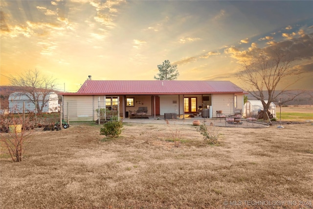 back house at dusk featuring an outdoor fire pit and a patio area