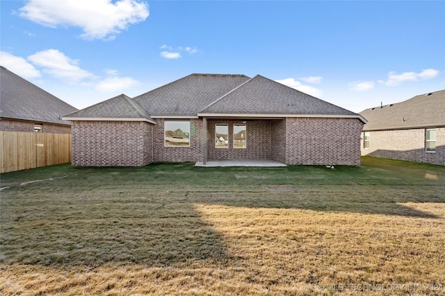 back of property featuring a lawn and a patio