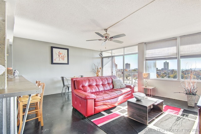 living room with ceiling fan and a textured ceiling