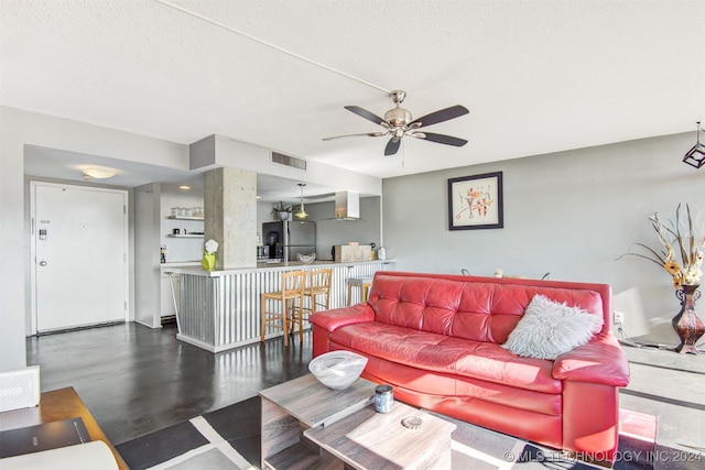 living room with ceiling fan and a textured ceiling