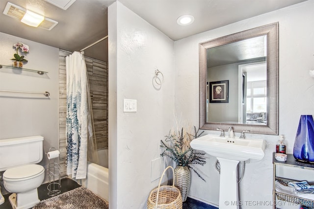 full bathroom featuring sink, shower / tub combo with curtain, and toilet