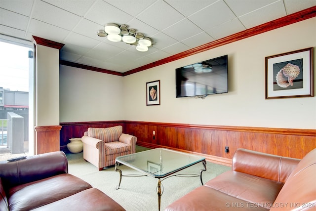 carpeted living room with ornamental molding and wooden walls