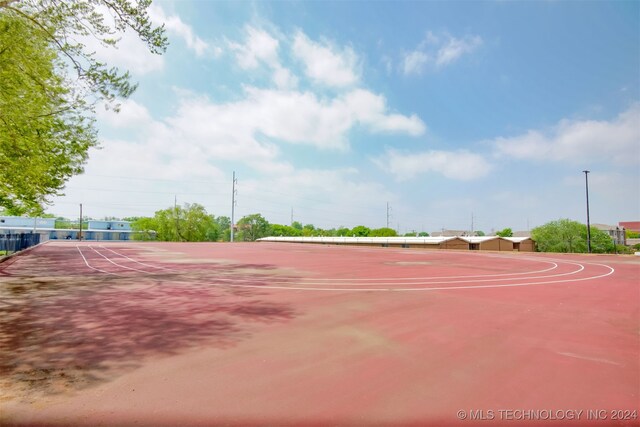 view of tennis court featuring basketball hoop