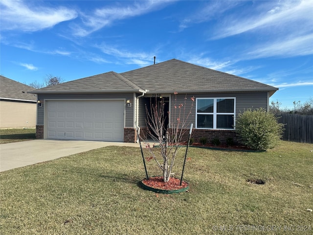 single story home featuring a garage and a front lawn