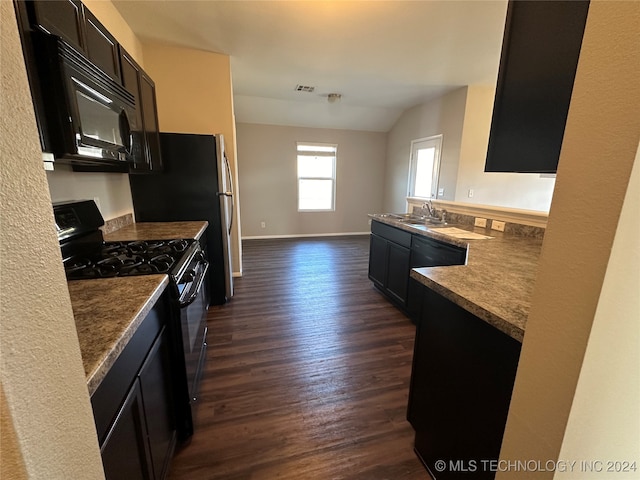 kitchen featuring lofted ceiling, black appliances, sink, dark hardwood / wood-style flooring, and kitchen peninsula