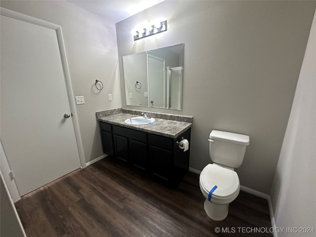 bathroom featuring vanity, hardwood / wood-style flooring, and toilet