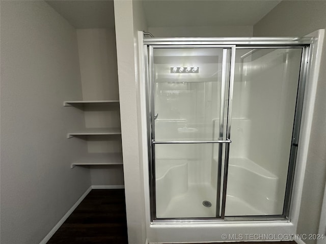 bathroom with hardwood / wood-style flooring and walk in shower