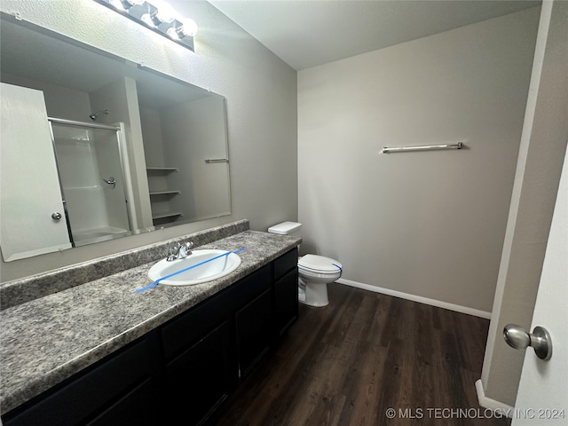 bathroom featuring hardwood / wood-style floors, vanity, an enclosed shower, and toilet