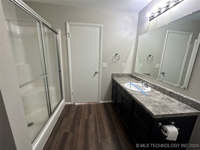 bathroom featuring wood-type flooring, vanity, and walk in shower