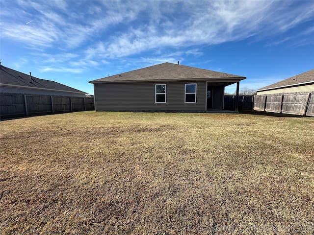 back of house featuring a lawn