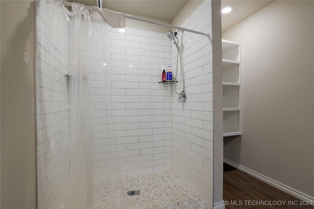 bathroom featuring hardwood / wood-style flooring and walk in shower