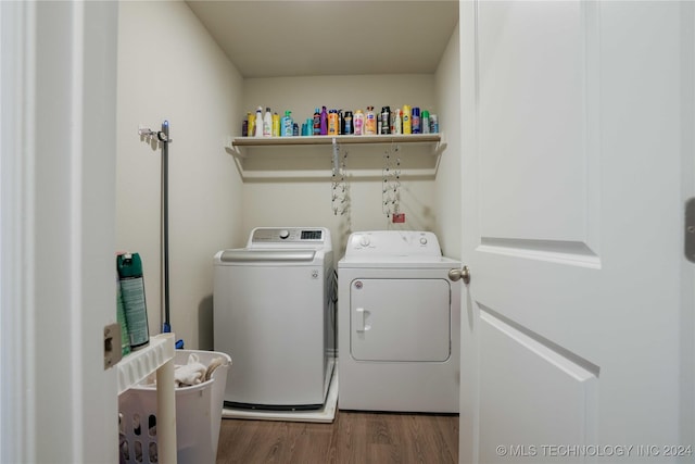 clothes washing area with washer and dryer and dark hardwood / wood-style floors