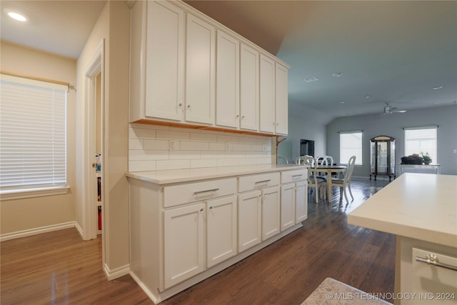 kitchen featuring white cabinets, decorative backsplash, ceiling fan, and dark wood-type flooring