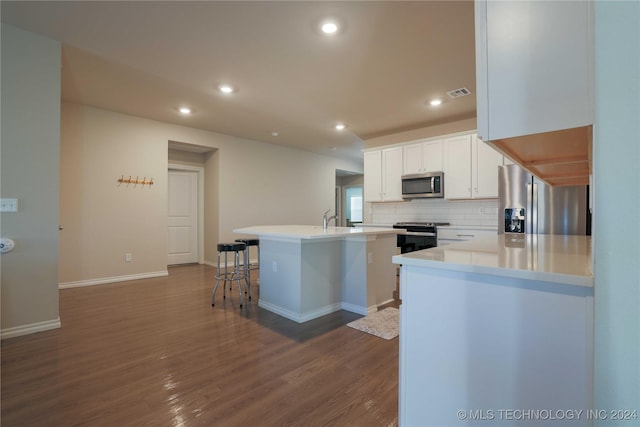 kitchen featuring appliances with stainless steel finishes, sink, wood-type flooring, a center island with sink, and white cabinets