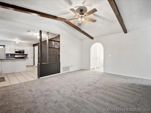 unfurnished living room with vaulted ceiling with beams, a textured ceiling, and light colored carpet