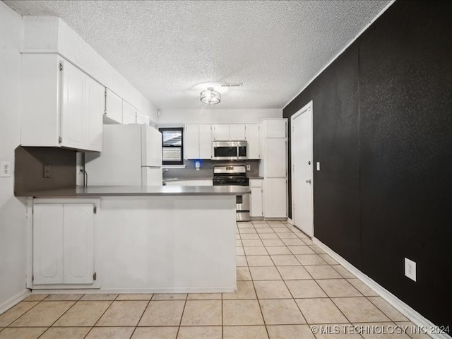 kitchen with kitchen peninsula, stainless steel appliances, white cabinetry, and light tile patterned flooring