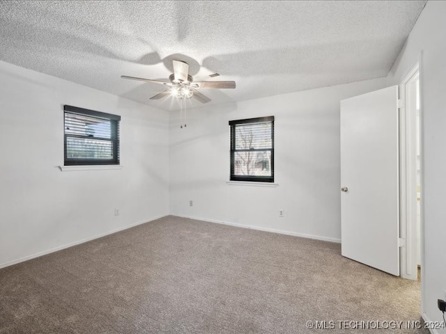 unfurnished room with a textured ceiling, light colored carpet, and ceiling fan