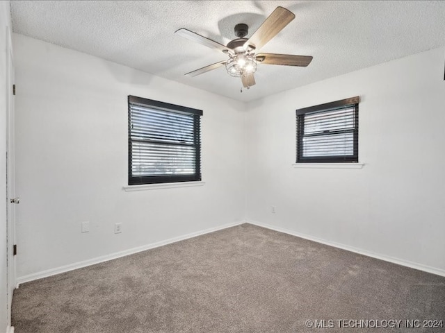 spare room featuring carpet flooring, ceiling fan, and a textured ceiling