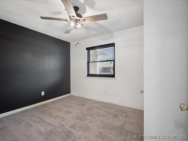 carpeted spare room with ceiling fan and a textured ceiling