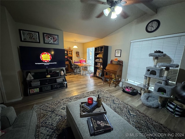 living room featuring lofted ceiling with beams, wood-type flooring, and ceiling fan with notable chandelier