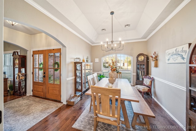 dining area featuring french doors, dark hardwood / wood-style floors, a raised ceiling, and a healthy amount of sunlight