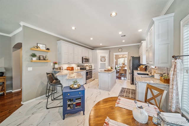 kitchen featuring plenty of natural light, a center island, white cabinetry, and appliances with stainless steel finishes