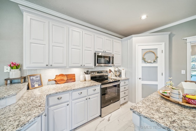 kitchen with backsplash, stainless steel appliances, white cabinetry, and ornamental molding