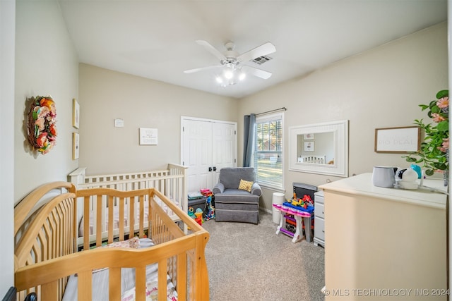 bedroom featuring carpet, a closet, a nursery area, and ceiling fan