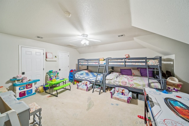 bedroom with carpet, ceiling fan, a textured ceiling, and vaulted ceiling