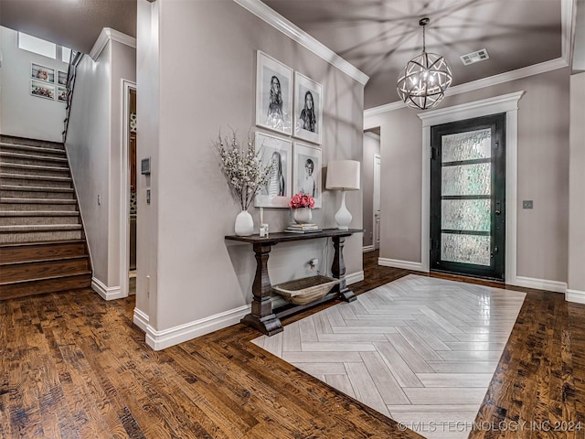 entryway featuring dark hardwood / wood-style flooring, ornamental molding, and an inviting chandelier