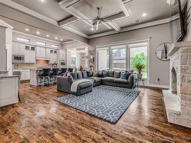 living room with coffered ceiling, crown molding, ceiling fan, beam ceiling, and dark hardwood / wood-style flooring