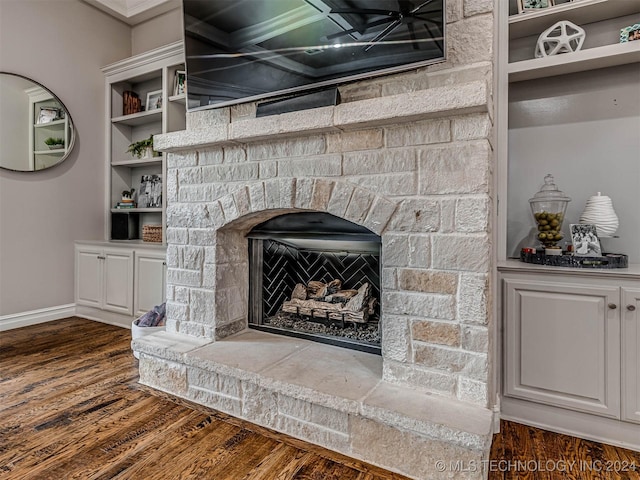 room details featuring a stone fireplace, hardwood / wood-style floors, and exhaust hood