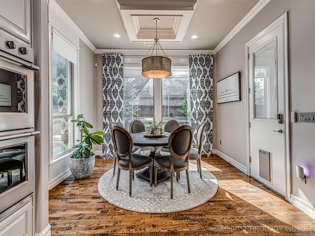 dining area with hardwood / wood-style flooring, plenty of natural light, and crown molding