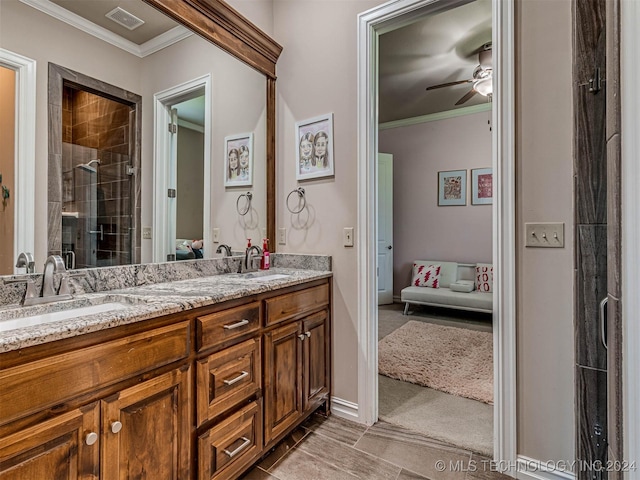 bathroom with crown molding, vanity, a shower with shower door, and ceiling fan