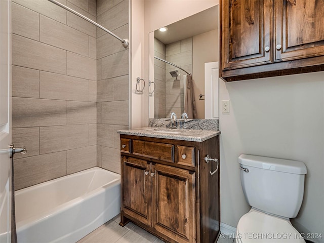 full bathroom with tile patterned floors, vanity, tiled shower / bath combo, and toilet