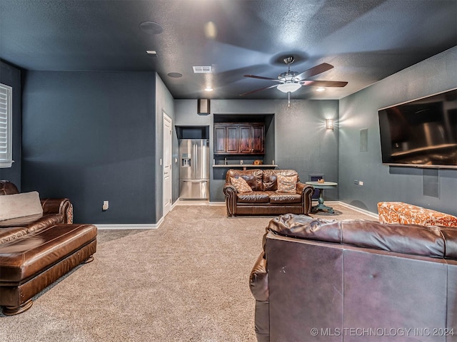 living room featuring light carpet, ceiling fan, and a textured ceiling