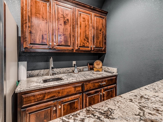 kitchen with light stone counters and sink