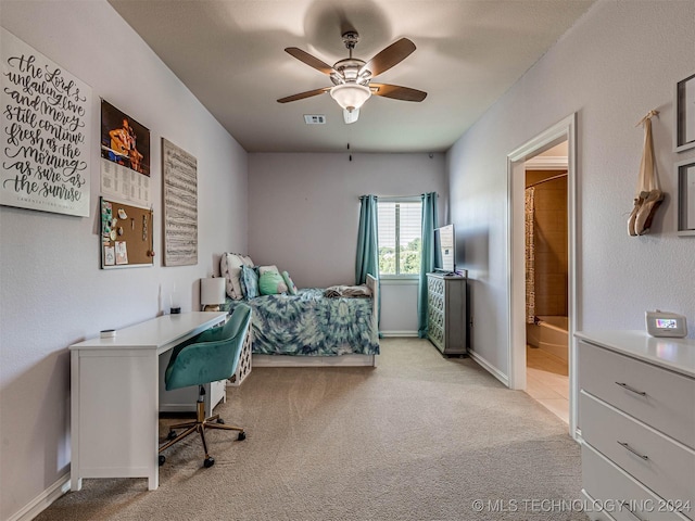 carpeted bedroom with ensuite bath and ceiling fan