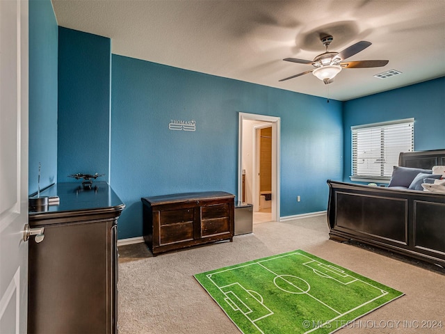 carpeted bedroom featuring ensuite bath and ceiling fan