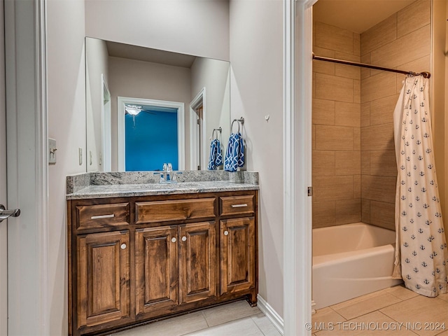 bathroom featuring tile patterned flooring, vanity, and shower / bathtub combination with curtain