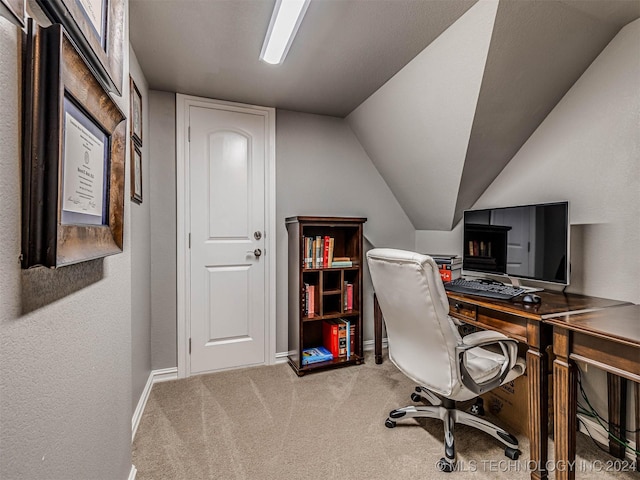 carpeted home office featuring lofted ceiling