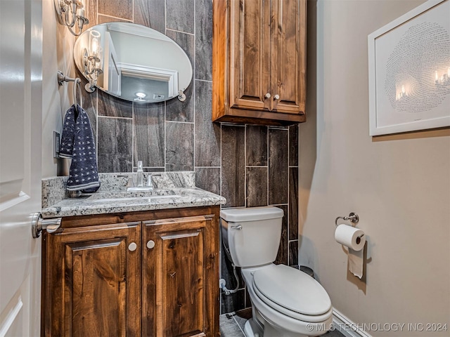 bathroom with vanity, toilet, and tasteful backsplash