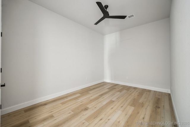 spare room with baseboards, ceiling fan, visible vents, and hardwood / wood-style floors