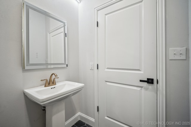 bathroom featuring a sink and baseboards