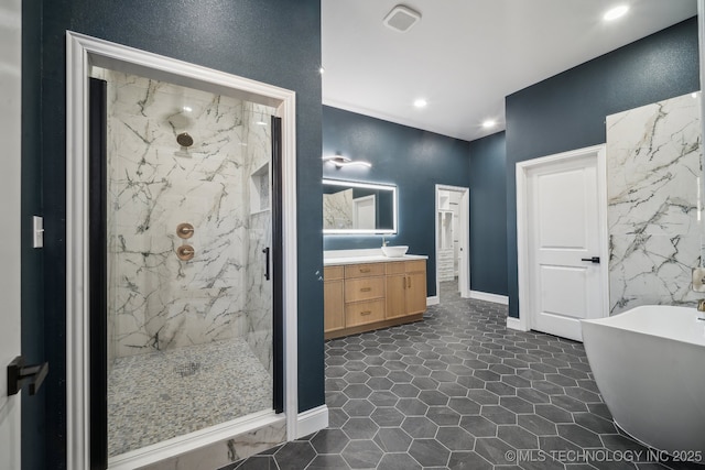 bathroom featuring a marble finish shower, baseboards, a freestanding bath, vanity, and recessed lighting