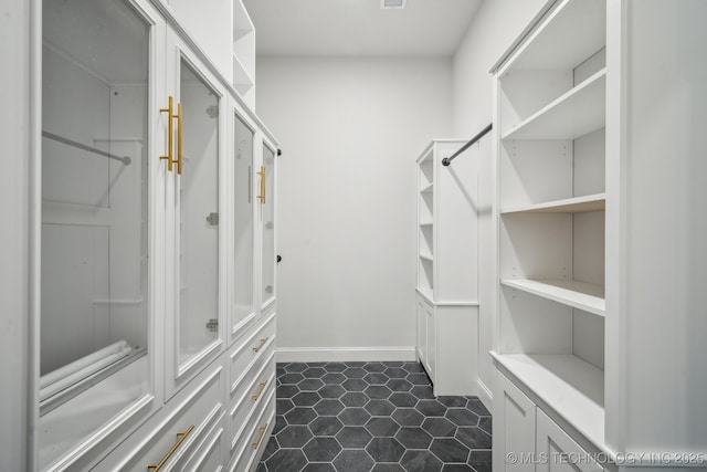 spacious closet with dark tile patterned flooring