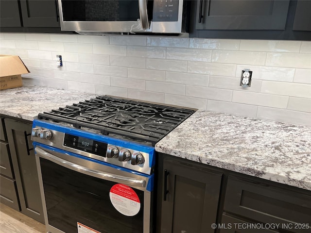 kitchen featuring tasteful backsplash, light stone countertops, and stainless steel appliances