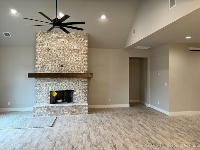 unfurnished living room featuring lofted ceiling, a fireplace, light hardwood / wood-style floors, and ceiling fan